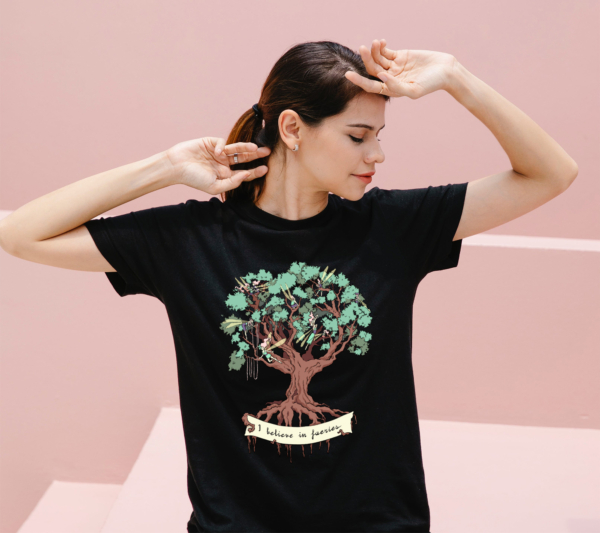 a woman wearing a black t-shirt with the I believe in fairies design by Natalia Salvador