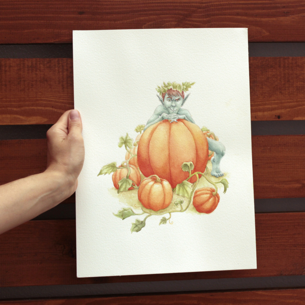 Pumpkin goblin illustration held by a hand